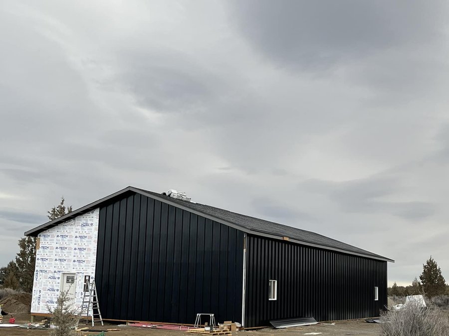 Black metal pole barn with vertical siding